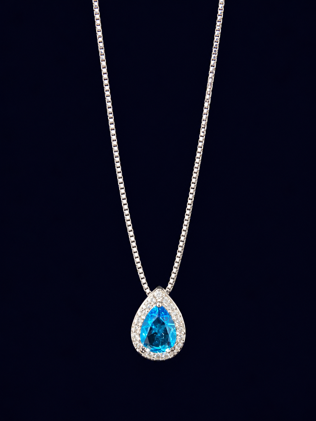 Colar com pingente em formato de gota azul cercado por detalhes claros.