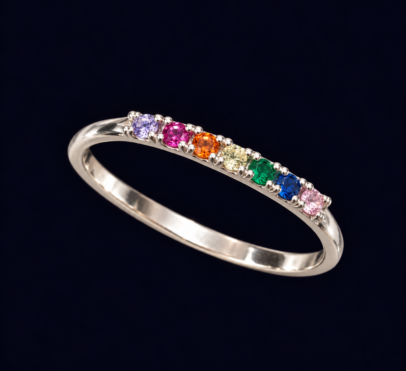 Anel de aro fino com uma sequência de pequenos detalhes multicoloridos.